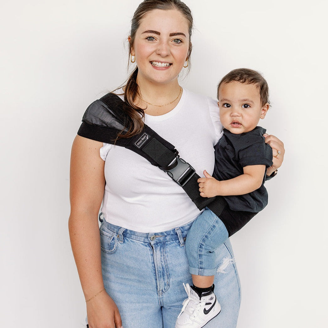 Parent carrying toddler in the Jet Black Rouu Baby II hip carrier
