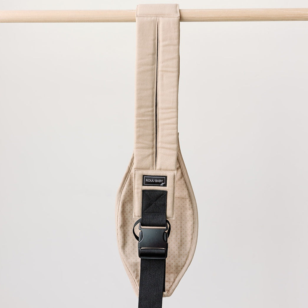 Side view of the Sand Beige Rouu Baby II hip carrier on the hip