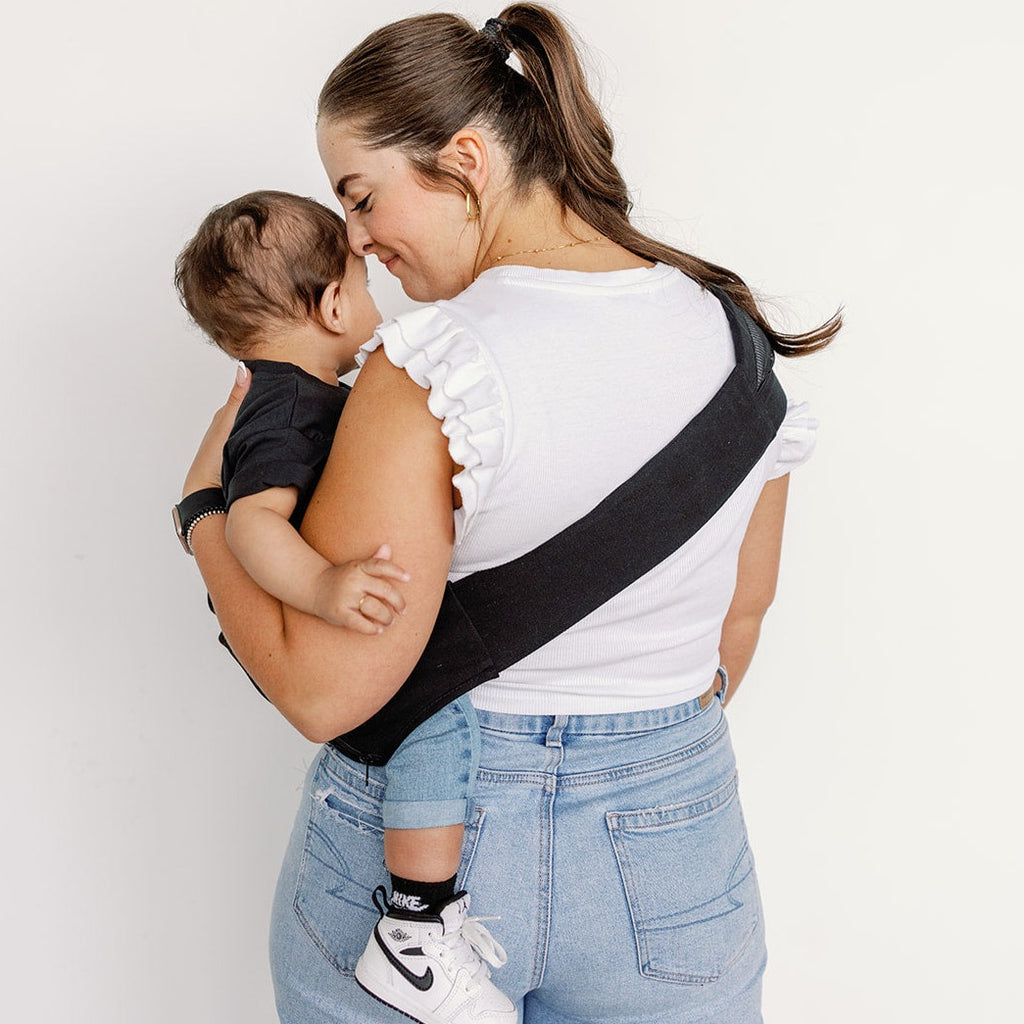 Baby seated in the Jet Black Rouu Baby II ergonomic hip carrier