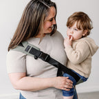 Side view of the Olive Rouu Baby II hip carrier worn on the hip