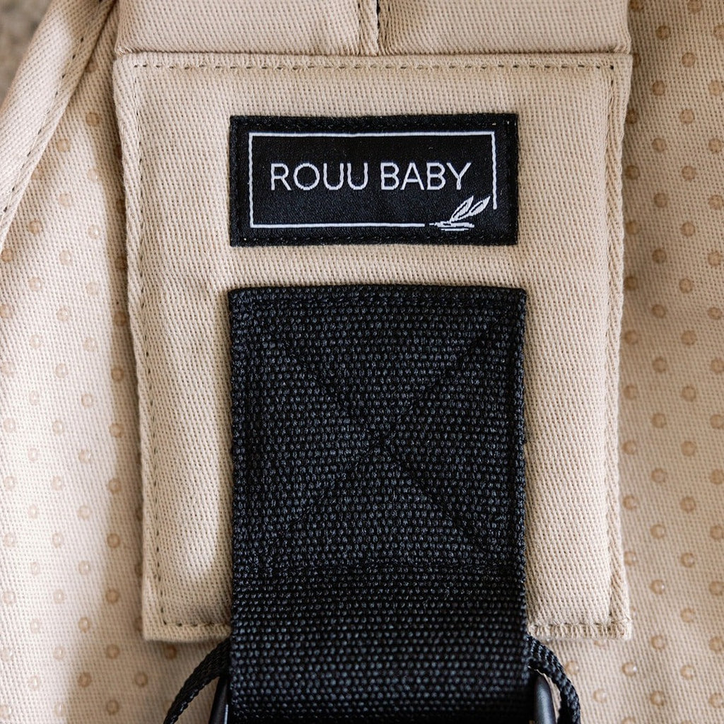 Baby seated in the Sand Beige Rouu Baby II ergonomic hip carrier